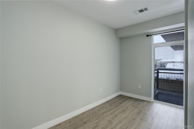 unfurnished room featuring light wood-style flooring, visible vents, and baseboards