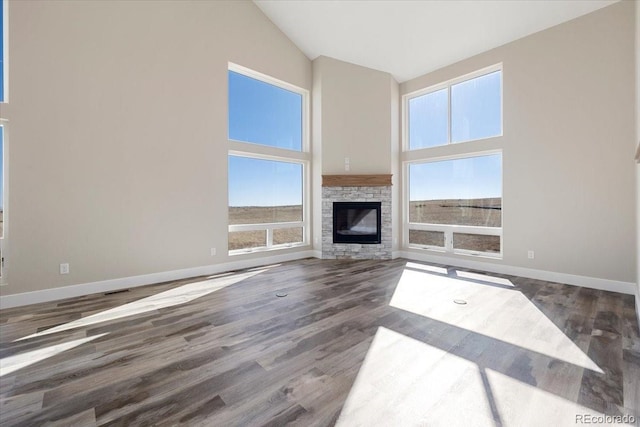 unfurnished living room featuring a fireplace, high vaulted ceiling, and dark hardwood / wood-style floors