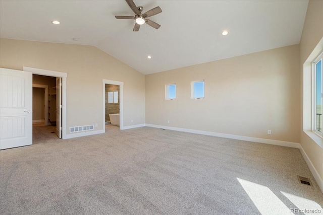 unfurnished bedroom featuring ceiling fan, ensuite bath, vaulted ceiling, and light carpet