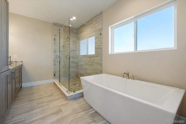 bathroom with vanity and shower with separate bathtub