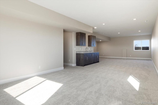 unfurnished living room with indoor bar and light colored carpet