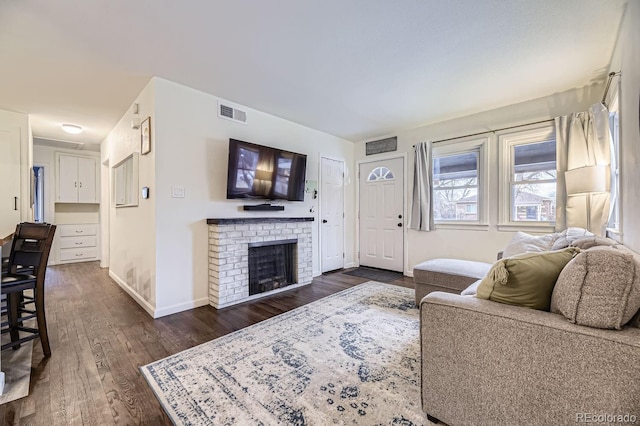 living room featuring dark wood-type flooring and a fireplace