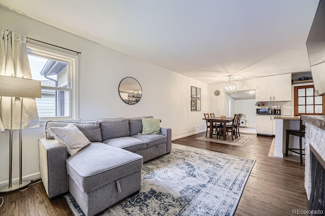 living room with a notable chandelier and dark hardwood / wood-style flooring