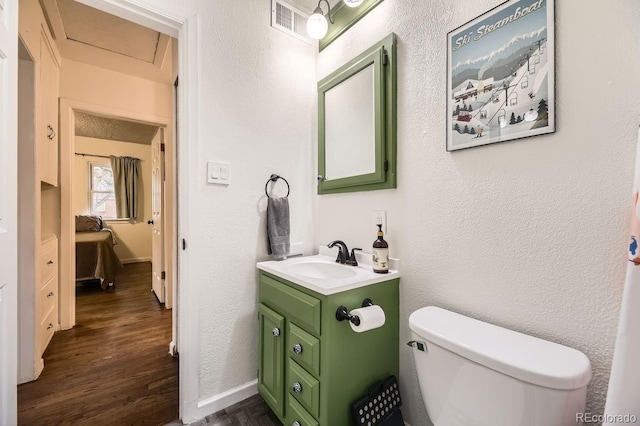 bathroom featuring wood-type flooring, toilet, and vanity