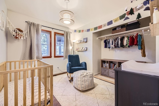 bedroom featuring a crib, vaulted ceiling, and a closet