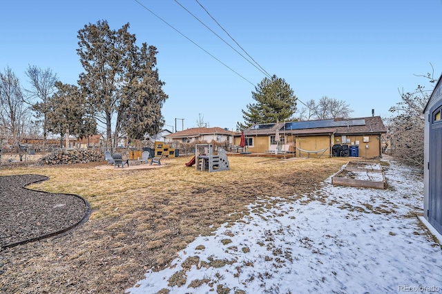 yard covered in snow featuring a playground and an outdoor fire pit