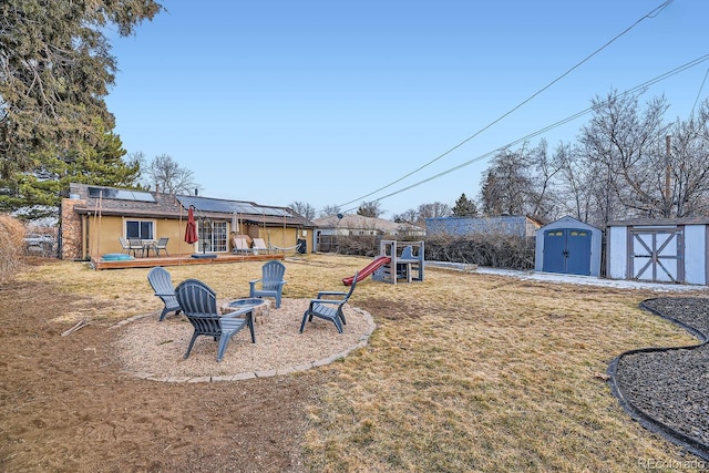 view of yard featuring a playground, a deck, and a storage shed