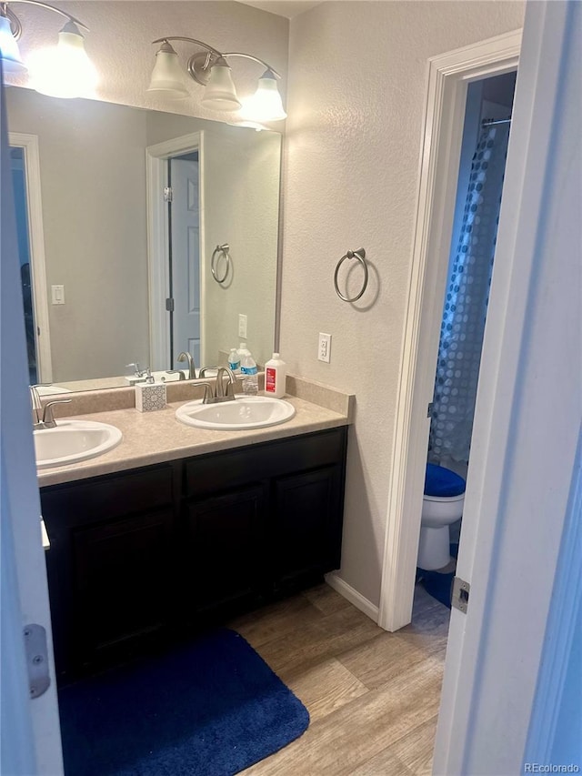 bathroom with hardwood / wood-style floors, toilet, and vanity