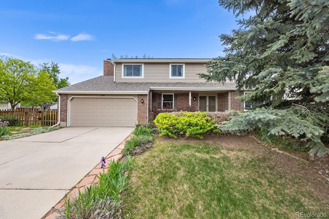 view of property featuring a garage and a front yard