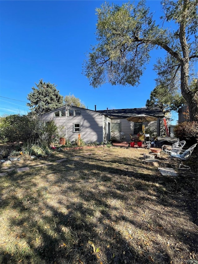 view of side of home with a patio and a lawn