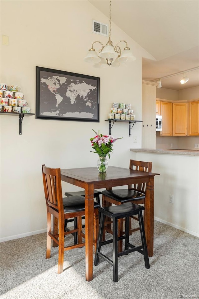 2250 S Vaughn Way Unit 204, Aurora, CO 80014 - dining space with a chandelier, light carpet, lofted ceiling, and track lighting