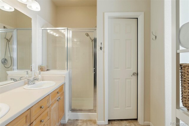 2250 S Vaughn Way Unit 204, Aurora, CO 80014 - bathroom featuring a stall shower, double vanity, and tile patterned floors