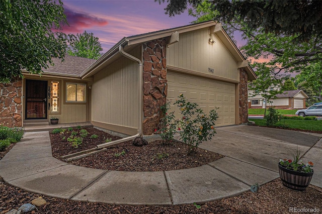 7582 S Newport Ct, Centennial, CO 80112 - mid-century home with driveway, an attached garage, and stone siding