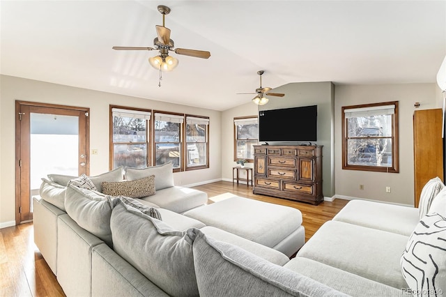 living room featuring ceiling fan, light hardwood / wood-style flooring, and vaulted ceiling