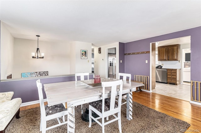 dining room featuring a notable chandelier and light wood-type flooring