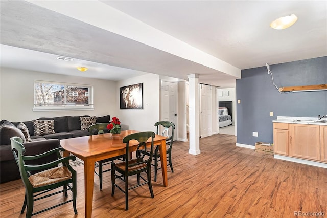 dining area with light wood-type flooring and sink