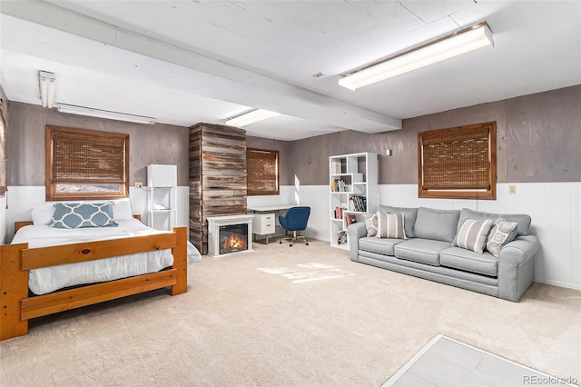 carpeted bedroom featuring wooden walls