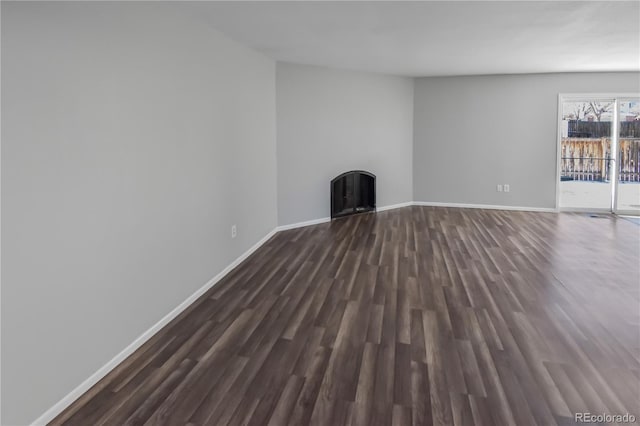 unfurnished living room with dark hardwood / wood-style flooring