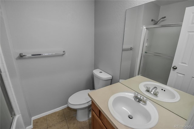 bathroom featuring walk in shower, vanity, tile patterned floors, and toilet