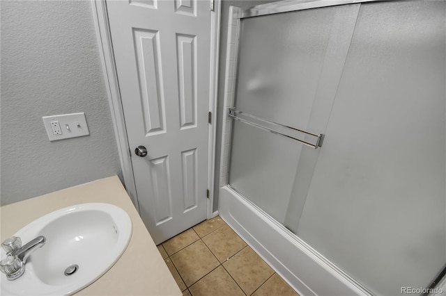 bathroom featuring sink, tile patterned floors, and combined bath / shower with glass door