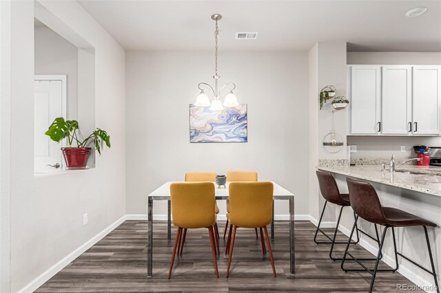 5187 S Fairplay St, Aurora, CO 80015 - dining area featuring a chandelier, baseboards, visible vents, and dark wood-style floors