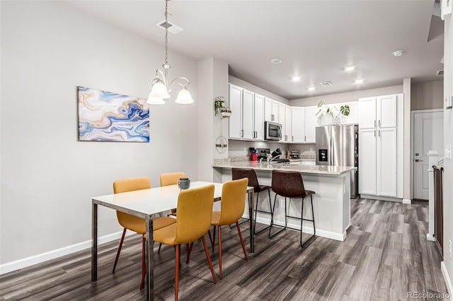 5187 S Fairplay St, Aurora, CO 80015 - dining area featuring visible vents, dark wood-style flooring, baseboards, recessed lighting, and a notable chandelier