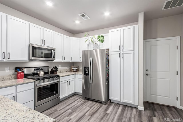 5187 S Fairplay St, Aurora, CO 80015 - kitchen featuring white cabinets, stainless steel appliances, visible vents, and light wood finished floors