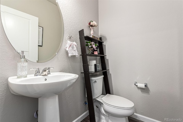 5187 S Fairplay St, Aurora, CO 80015 - half bathroom with toilet, baseboards, a sink, and wood finished floors
