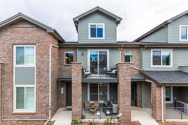 5187 S Fairplay St, Aurora, CO 80015 - view of front of house featuring brick siding, a balcony, and a patio area