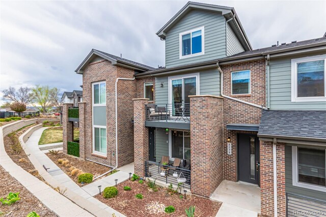 5187 S Fairplay St, Aurora, CO 80015 - view of front of property featuring a patio, brick siding, and a balcony