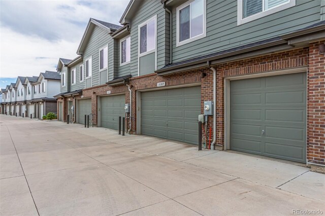 5187 S Fairplay St, Aurora, CO 80015 - view of property exterior with brick siding, an attached garage, and a residential view