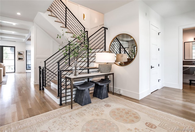 stairway with beam ceiling and hardwood / wood-style floors