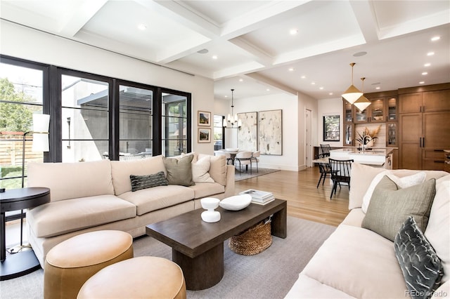 living room with beam ceiling, sink, light hardwood / wood-style flooring, and coffered ceiling