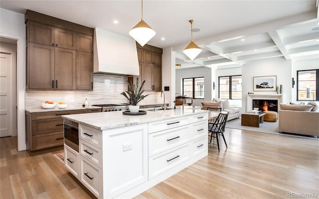 kitchen with premium range hood, white cabinetry, hanging light fixtures, and coffered ceiling