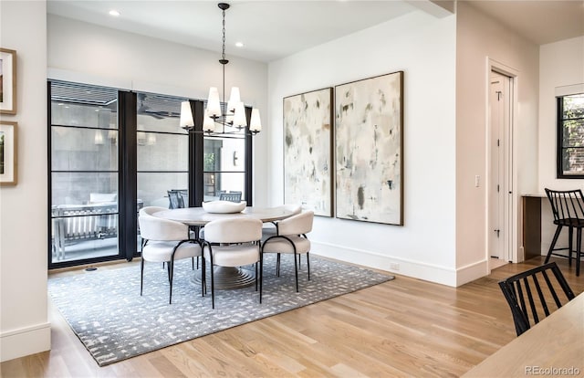 dining room with hardwood / wood-style floors and an inviting chandelier