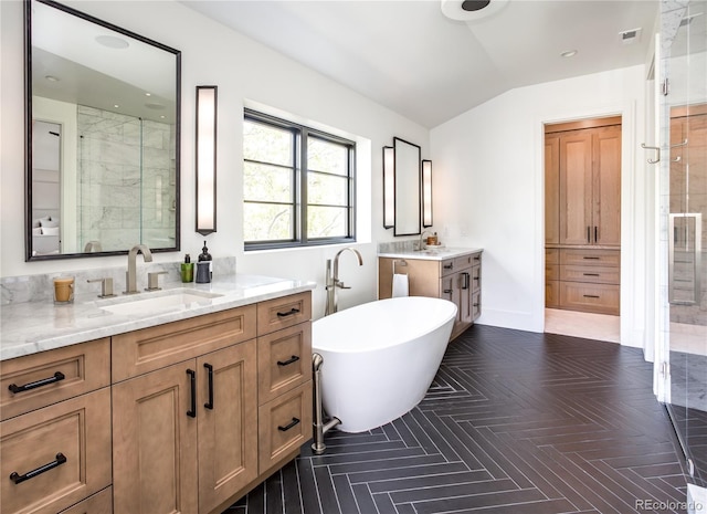 bathroom with a tub to relax in, vanity, and lofted ceiling