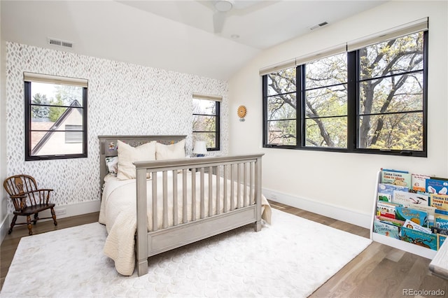 bedroom with hardwood / wood-style flooring and lofted ceiling