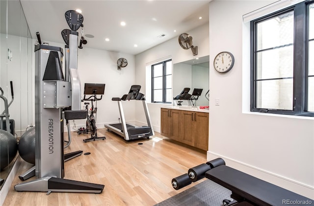 workout area with light hardwood / wood-style flooring