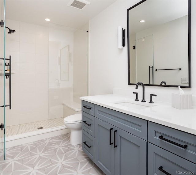 bathroom featuring tiled shower, vanity, and toilet