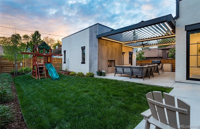 yard at dusk featuring a playground, a patio area, and an outdoor living space