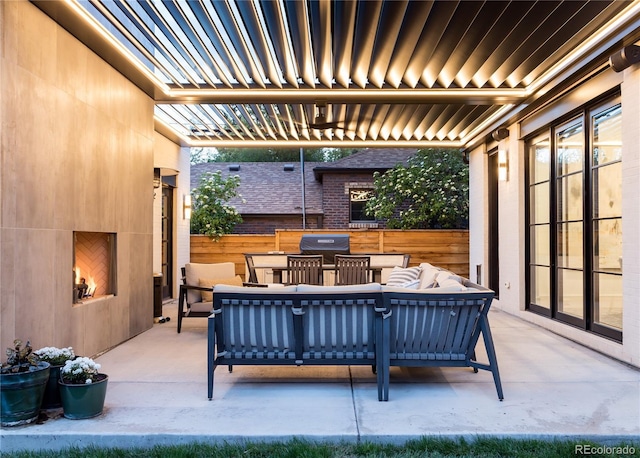 view of patio / terrace with an outdoor living space with a fireplace and grilling area