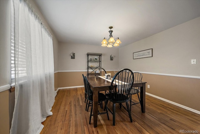 dining space featuring hardwood / wood-style floors and a notable chandelier