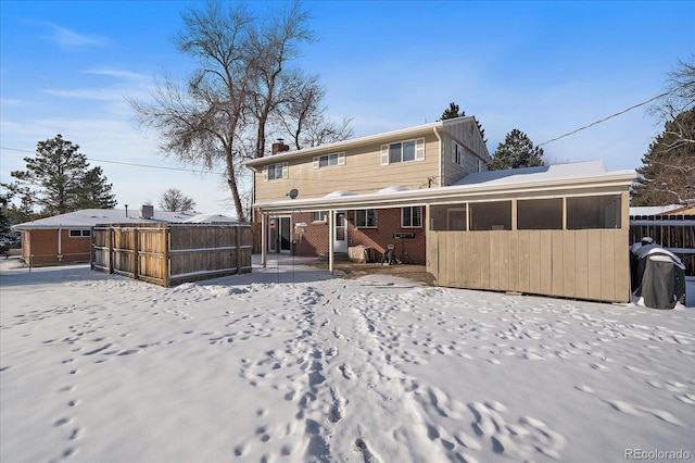 view of snow covered back of property