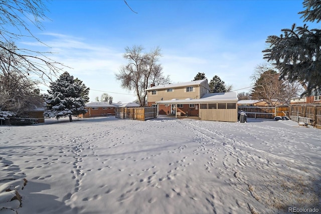 snowy yard featuring a sunroom