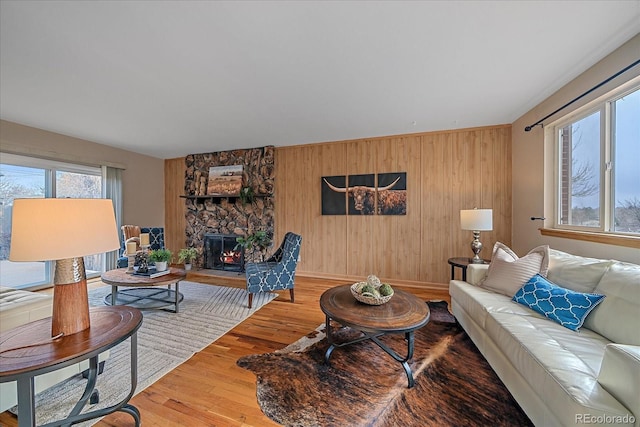 living area with wood finished floors, a fireplace, and wood walls