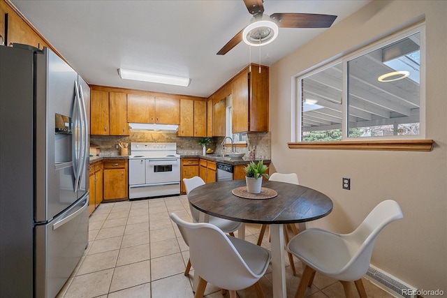 kitchen with brown cabinetry, visible vents, under cabinet range hood, and stainless steel appliances