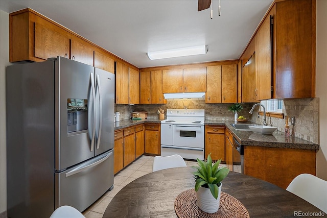 kitchen featuring electric range, stainless steel refrigerator with ice dispenser, a sink, under cabinet range hood, and brown cabinetry