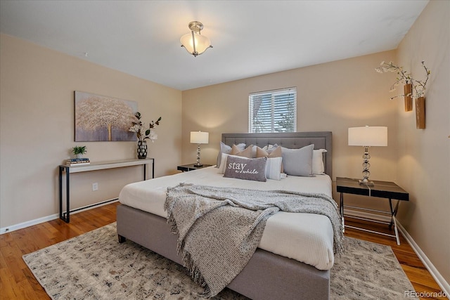 bedroom with baseboards and wood finished floors