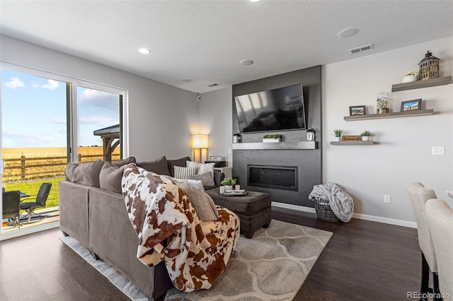 living room featuring a textured ceiling, a fireplace, and dark hardwood / wood-style flooring