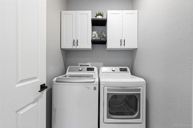 washroom featuring washer and clothes dryer and cabinets